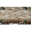 Stylová restaurace s obkladem Dublin Multi-Brick – detail rustikální cihlové stěny za koženým boxem k sezení a sklenicemi na víno